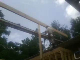 Carpenter setting a ridge beam over a new addition frame — Ice Dam Removal by Roofing Brothers in Passaic