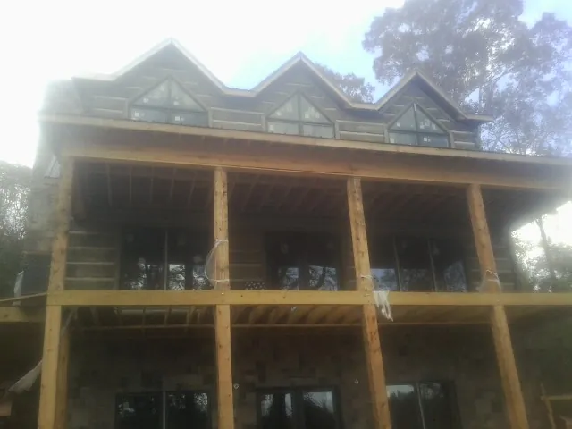 Dormers and porch framing on a large log home under construction — Roof Coating work by our crew in Passaic