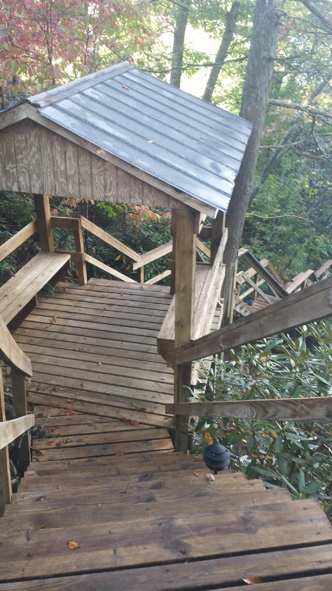 Metal roofed shelter over wooden steps on a wooded walkway — Skylight Repair & Installation work by our crew in Passaic
